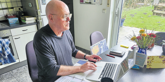 Seniorenstudent Elmar Schleiden arbeitet an seinem Laptop in seiner heimischen Küche
