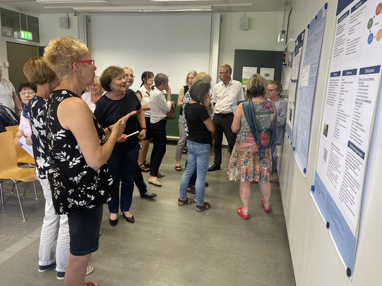Seniorenstudierende der 45. Studiengruppe schauen sich Projekte-Plakate genauer an